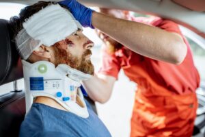 paramedic applying bandages on victims head after car accident