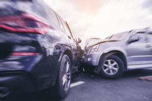 silver SUV crashing into the passenger side of dark colored SUV