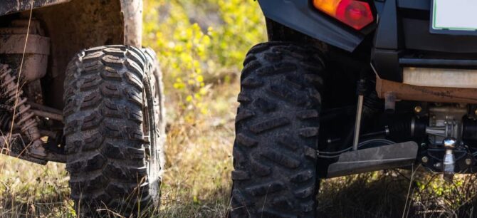 close up of rear end of off highway vehicles parked in grass