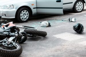 scene of an accident with motorcycle turned over and helmet strewn on the pavement