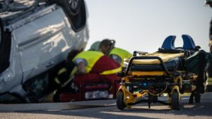 Paramedics and firefighters on a car accident scene, to recue a catastrophic injured victim trapped in rollover vehicle.