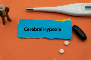 piece of paper with 'Cerebral Hypoxia' written on it, thermometer pictured above, small white pills pictured below, cerebral hypoxia medical concept